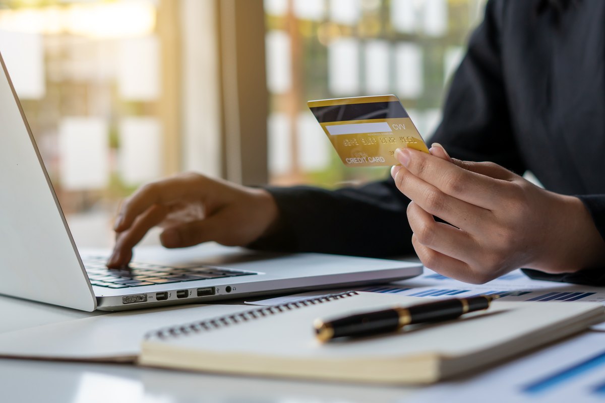 پرداخت آنلاین هزینه آزمون با کارت اعتباری پشت لپتاپ
